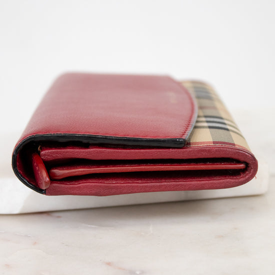 Folded red leather wallet with checkered pattern on a marble surface
