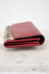 Red wallet with checkered pattern on a marble surface
