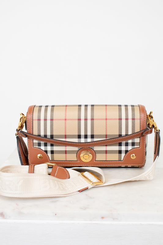 Plaid handbag with brown leather accents on a white background