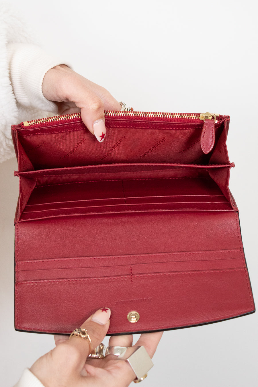 Red handbag held open by a person with a white background