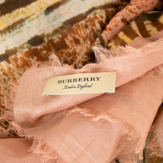 Close-up of tag on light pink and neutral tone scarf with 'Burberry' branded on tag