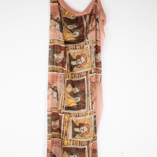 Light material scarf with framed portraits in neutral tone colors hanging on a wooden hanger against a plain background