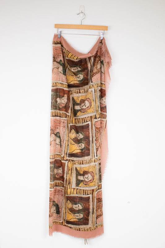 Light material scarf with framed portraits in neutral tone colors hanging on a wooden hanger against a plain background