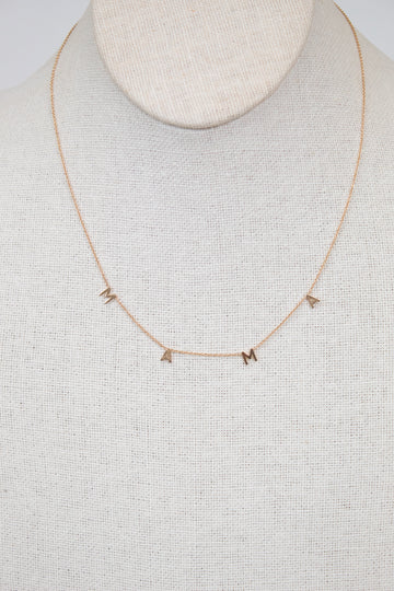 Gold necklace with "MAMA" letters on cream bust