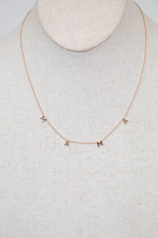 Gold necklace with "MAMA" letters on cream bust