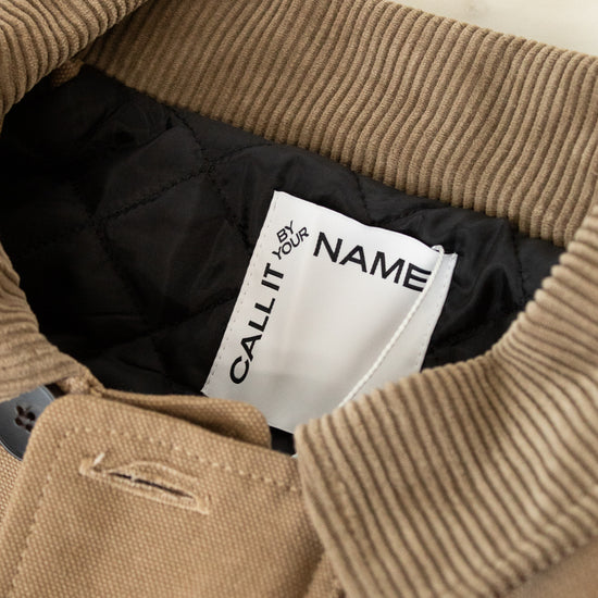 Close-up of a brown jacket with a visible brand label inside.
