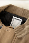 Close-up of a brown jacket with a visible brand label inside.