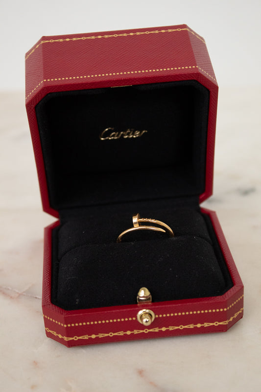 Gold ring in a Cartier box on a marble surface