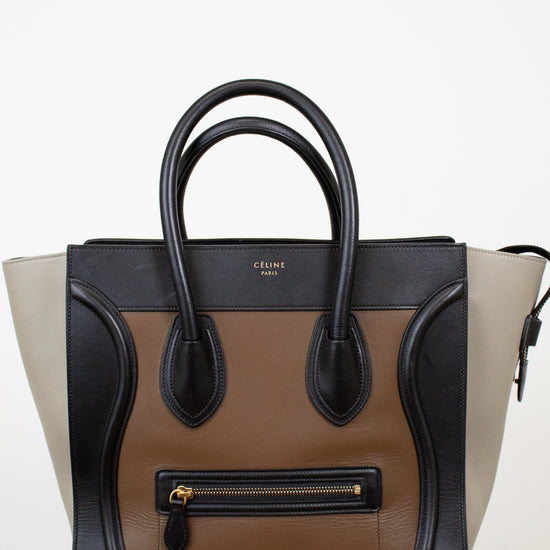 Designer handbag with black, brown, and beige color scheme on a white background
