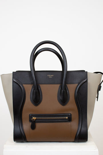 Designer handbag with black, brown, and beige color scheme on a white background