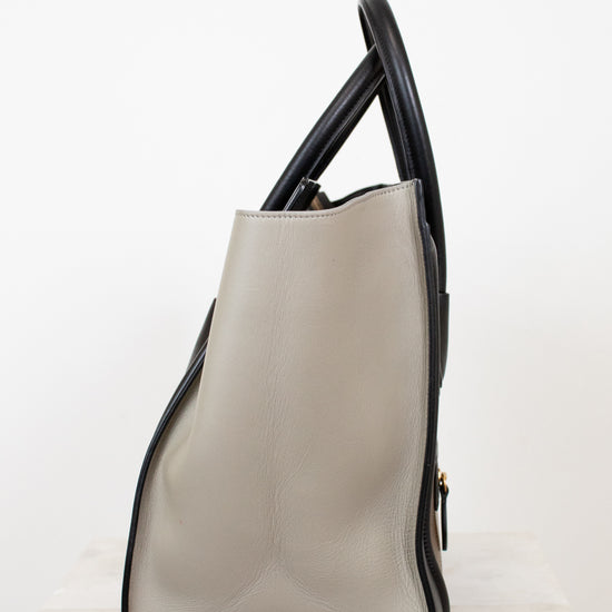 Beige handbag with black accents on a white background