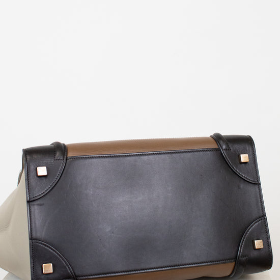 Black leather base of tote bag with brown accents on a white background