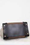 Black leather base of tote bag with brown accents on a white background