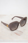 Sunglasses with a gold logo on a marble surface