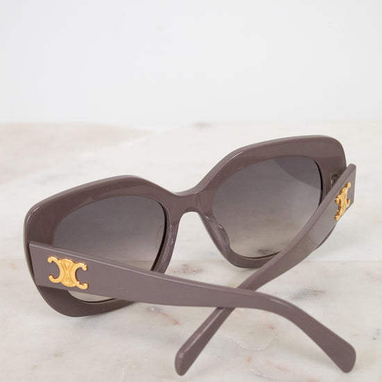Sunglasses with gold accents on a light marble background