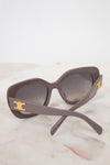 Sunglasses with gold accents on a light marble background