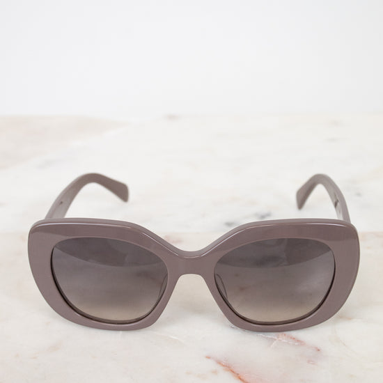 Cat-eye sunglasses with a gradient lens on a marble surface