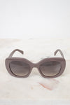 Cat-eye sunglasses with a gradient lens on a marble surface