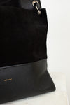 Black handbag with gold logo on a light background
