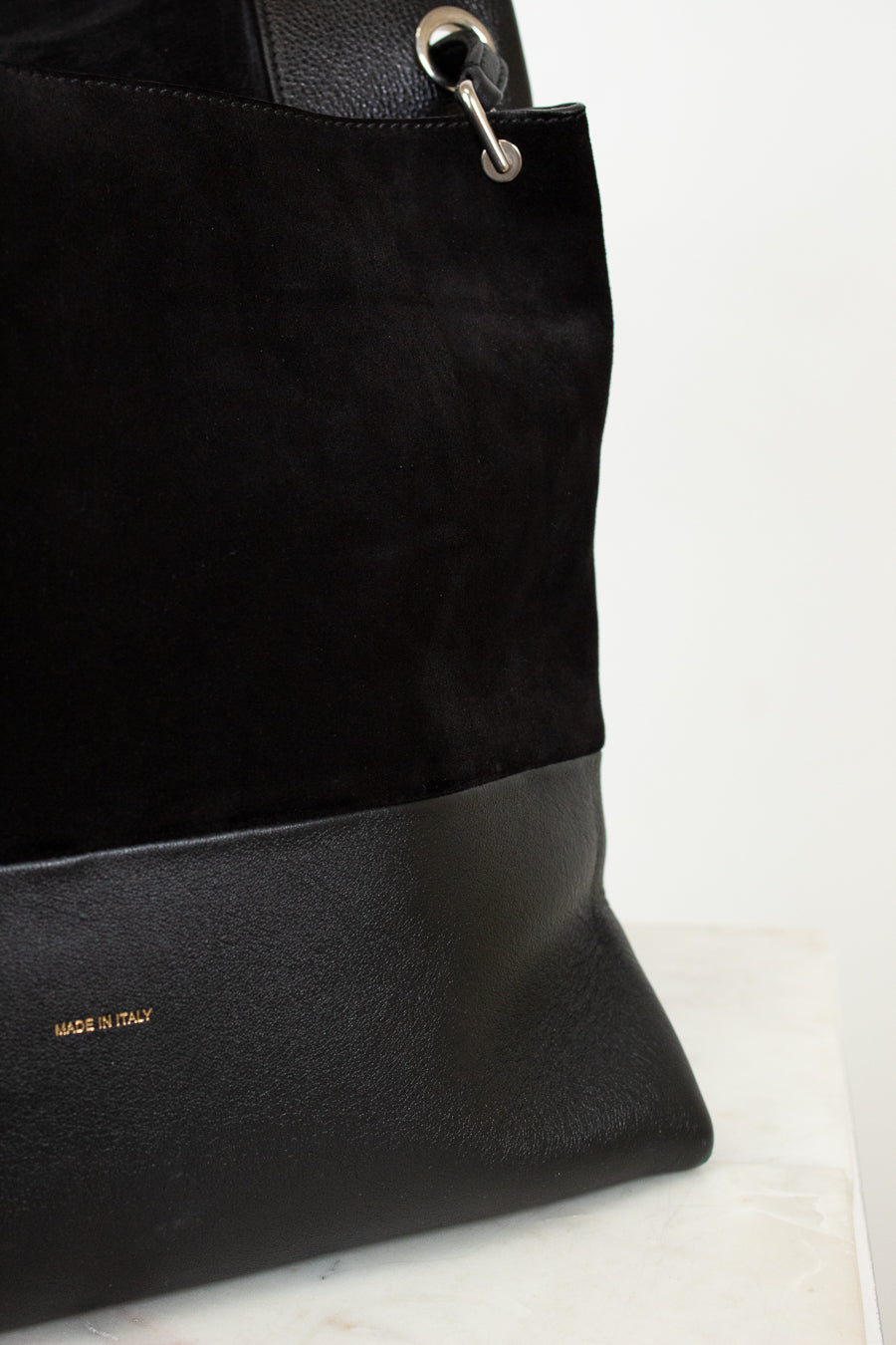 Black handbag with gold logo on a light background