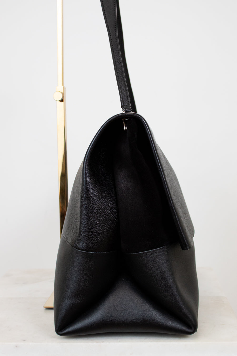 Black leather handbag on a light gray background