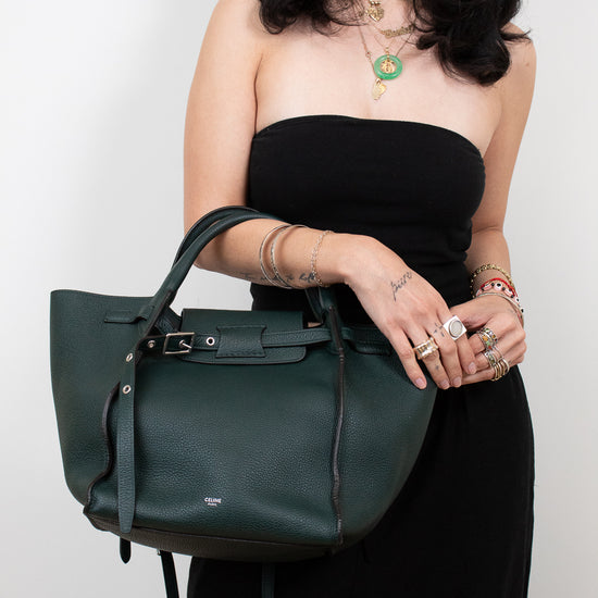 Woman holding a green handbag against a white background