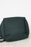 Green leather handbag on a light gray background
