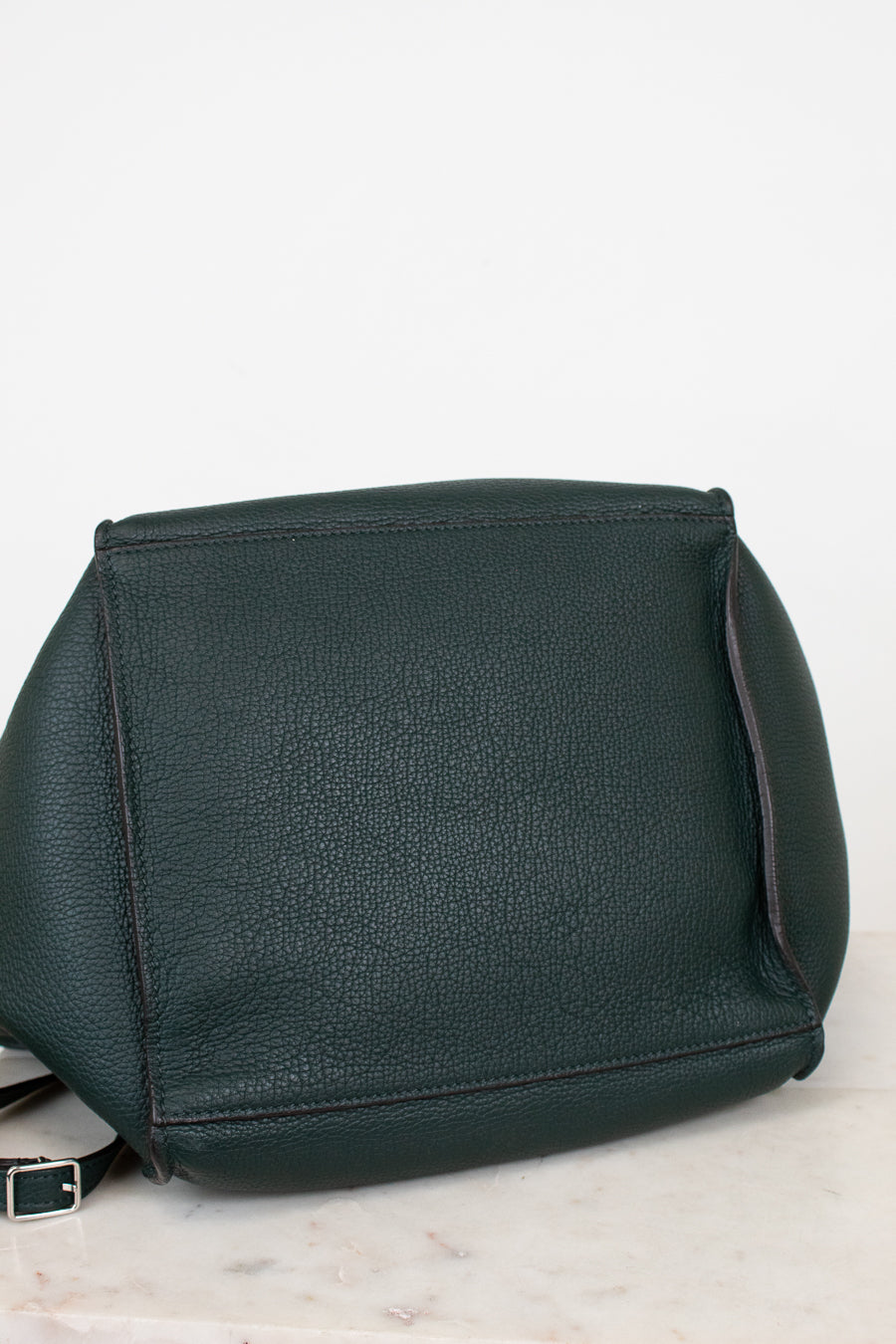 Green leather handbag on a light gray background