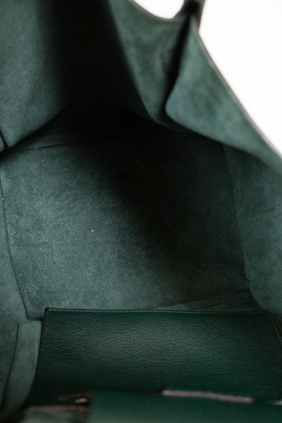Close-up of a green leather bags interior with visible stitching