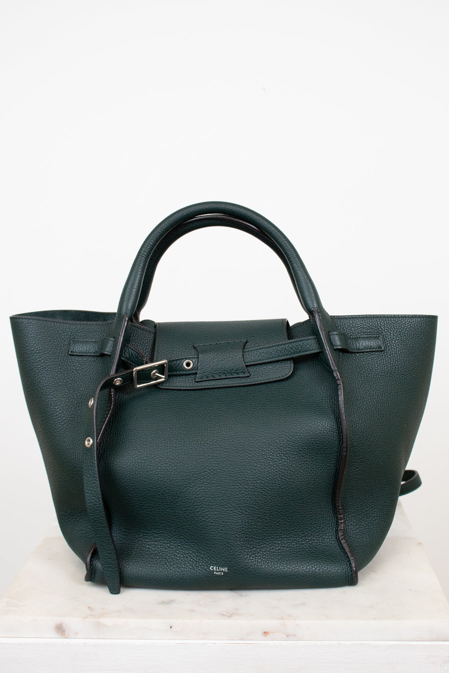 Green handbag with a strap on a white background