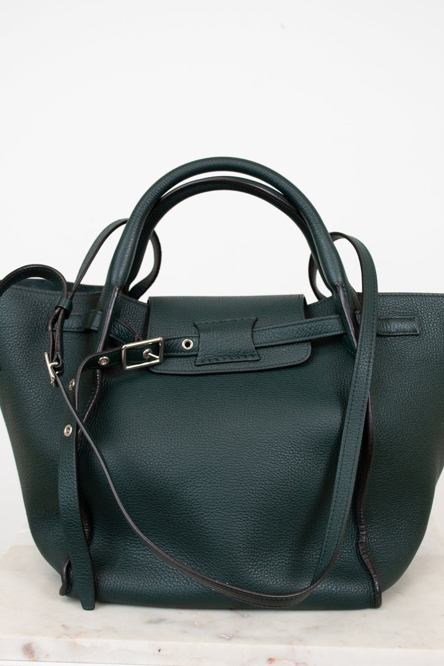 Green handbag with a strap on a white background