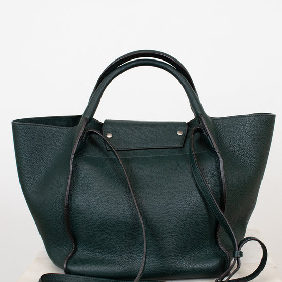 Dark green leather handbag with a shoulder strap on a white background
