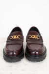 Pair of brown loafers with gold chain detail on a white background