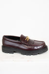 Brown loafer shoe with gold buckle on a white background