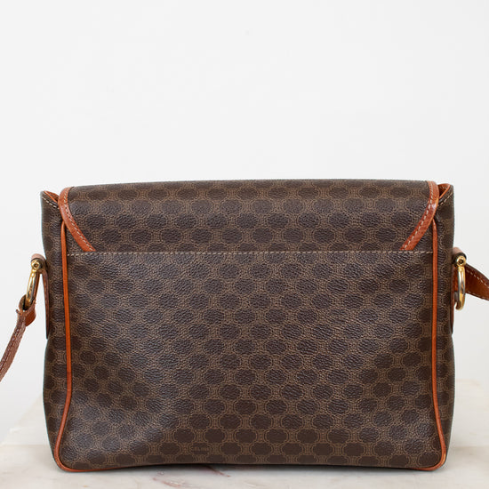 Brown patterned handbag with orange accents on a white background