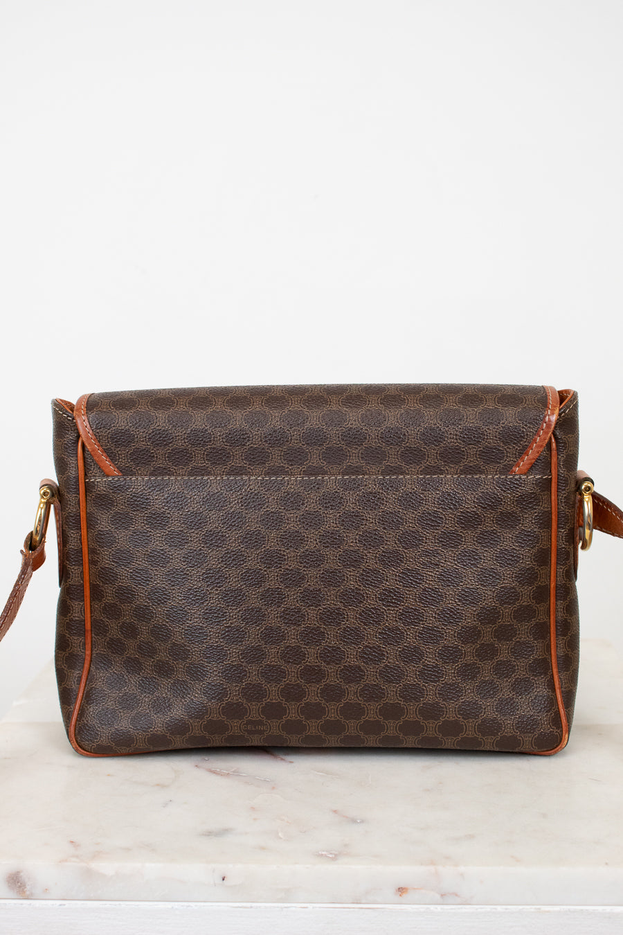 Brown patterned handbag with orange accents on a white background