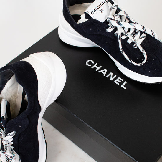 Chanel sneakers on a black box with a white background