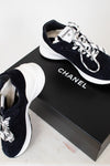 Chanel sneakers on a black box with a white background