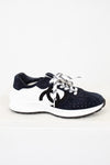 Pair of Chanel navy blue sneakers with white laces on a light gray background