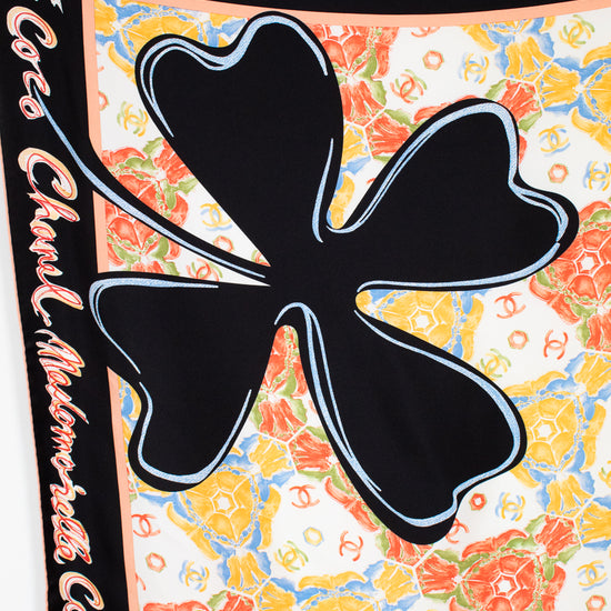 Colorful floral patterned fabric with a black clover design and 'Chanel' branding.