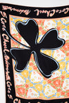 Colorful floral patterned fabric with a black clover design and 'Chanel' branding.