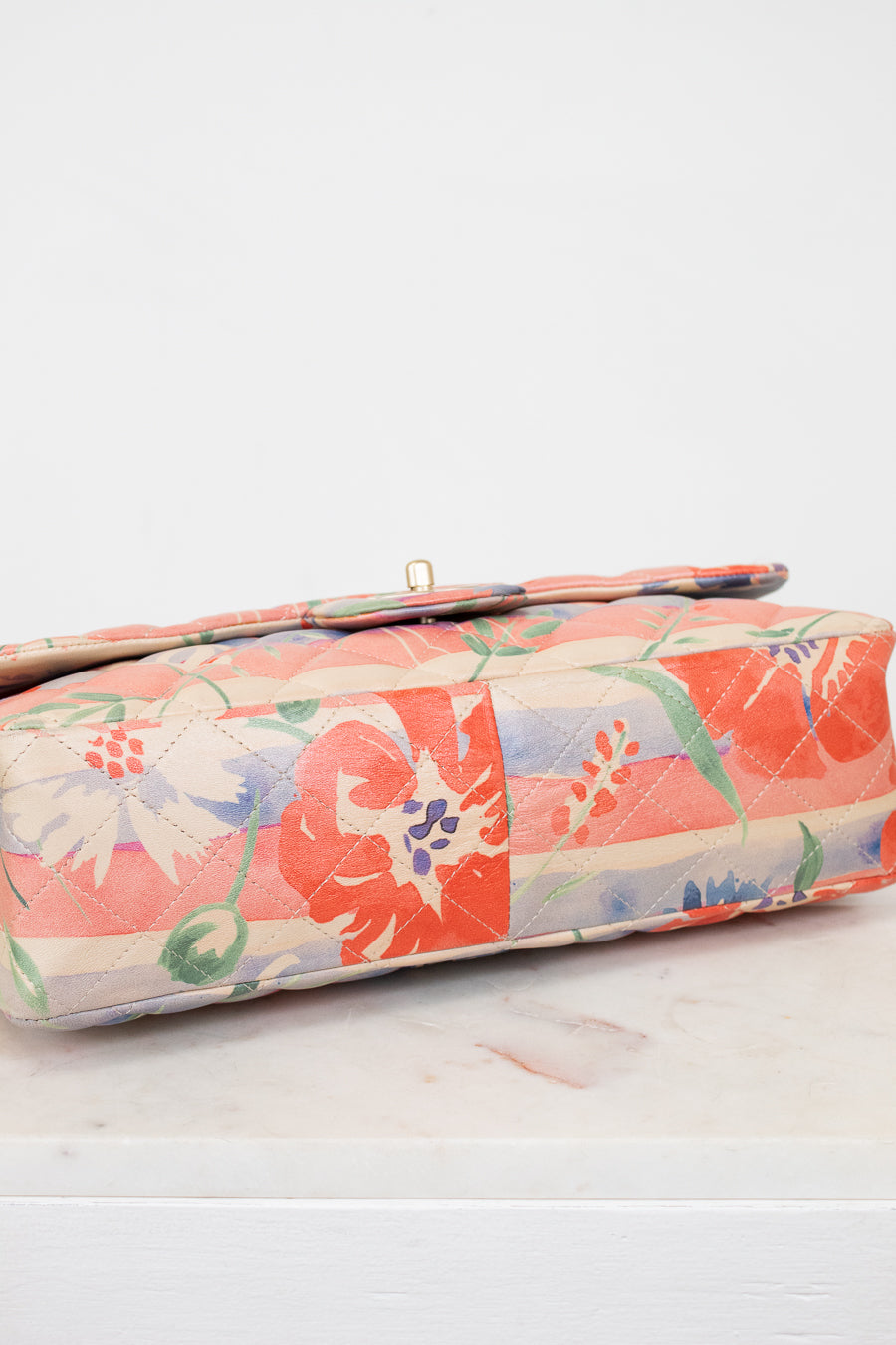 Floral-patterned crossbody bag base on a light surface