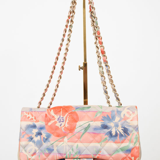 Floral quilted handbag with gold chain strap on a white background
