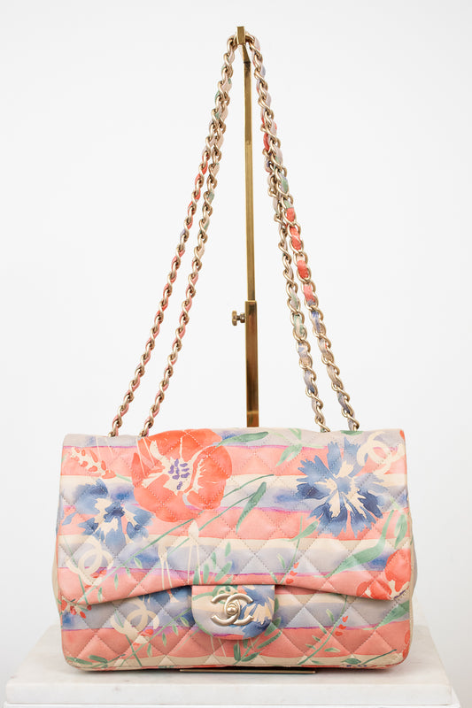 Floral quilted handbag with gold chain strap on a white background