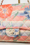 Floral-patterned handbag with Chanel logo on a light background