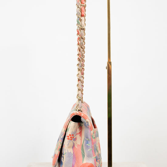 Side view of floral patterned handbag with a gold chain strap on a white background