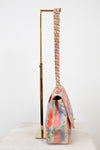 Side view of floral-patterned handbag with a chain strap on a white background