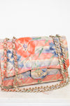Floral patterned handbag with gold chain on a white background