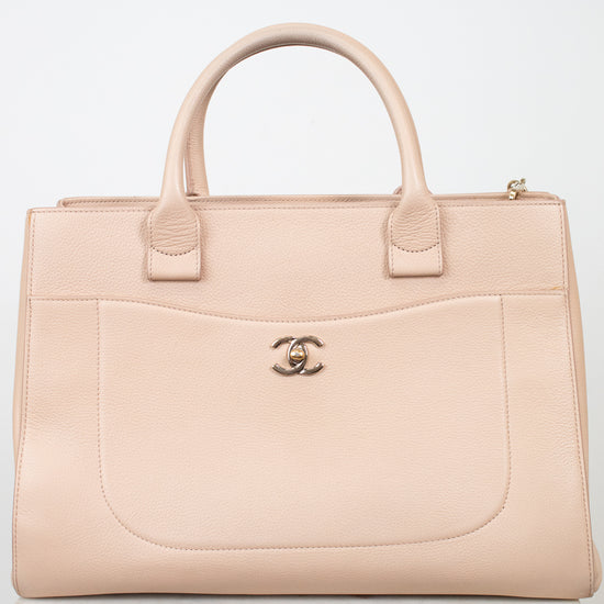 Beige handbag with Chanel logo on a white background