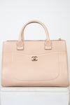 Beige handbag with Chanel logo on a white background